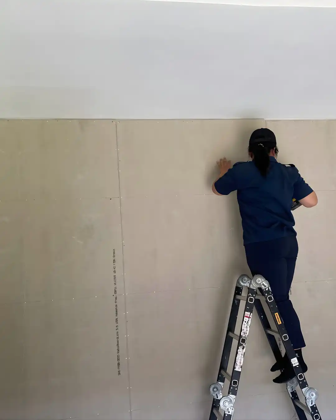 Proclean ProFix decorator on a ladder preparing a wall for painting