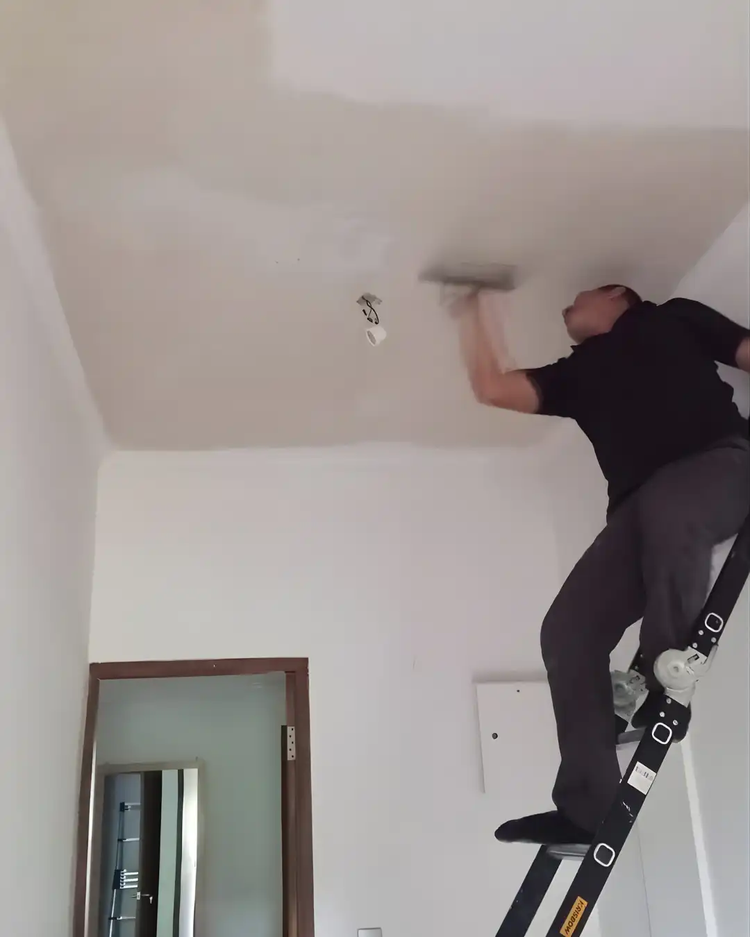 Proclean ProFix decorator on a ladder finishing a ceiling in a Hong Kong flat