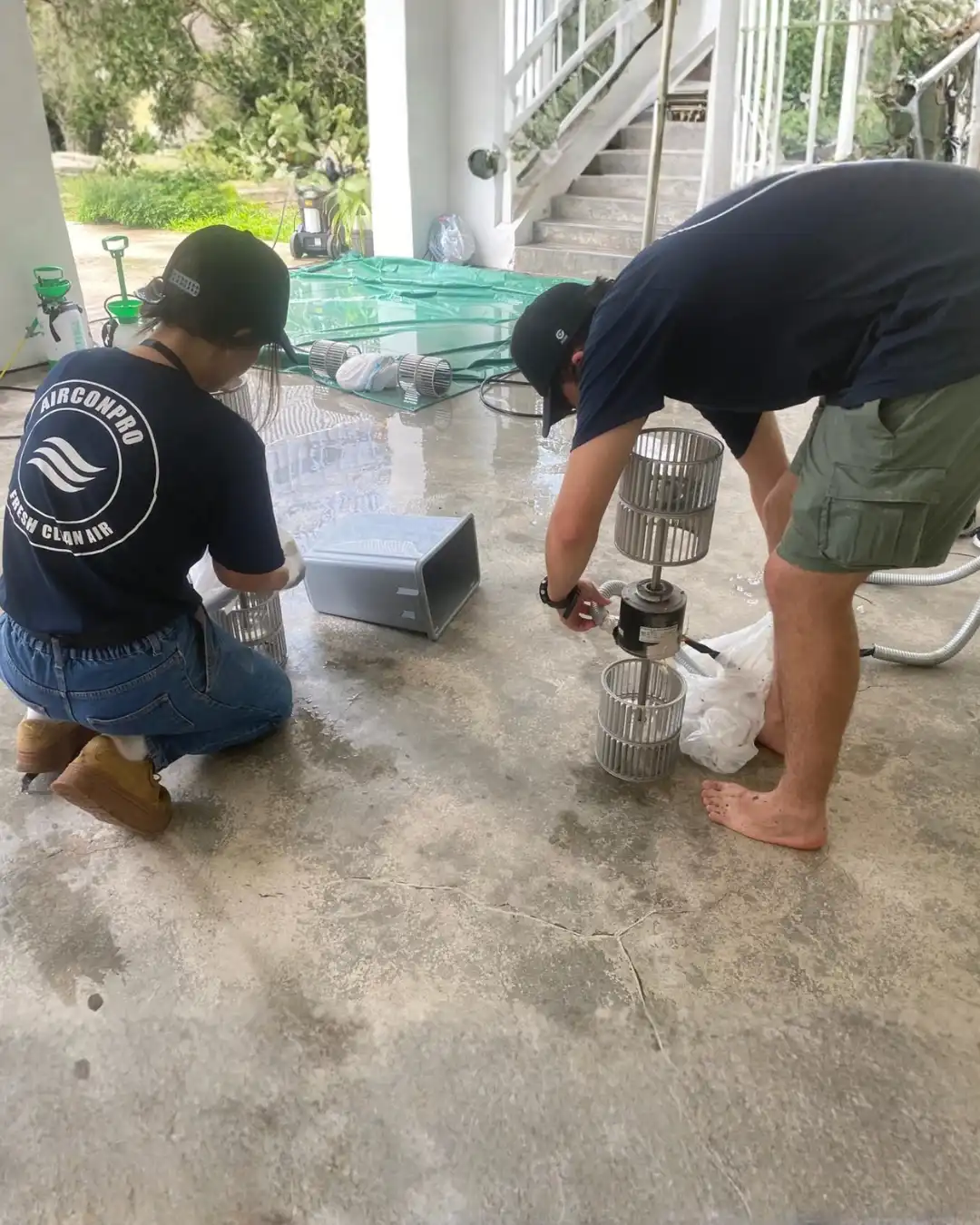 AirconPro team members working on equipment outdoors during on-site training