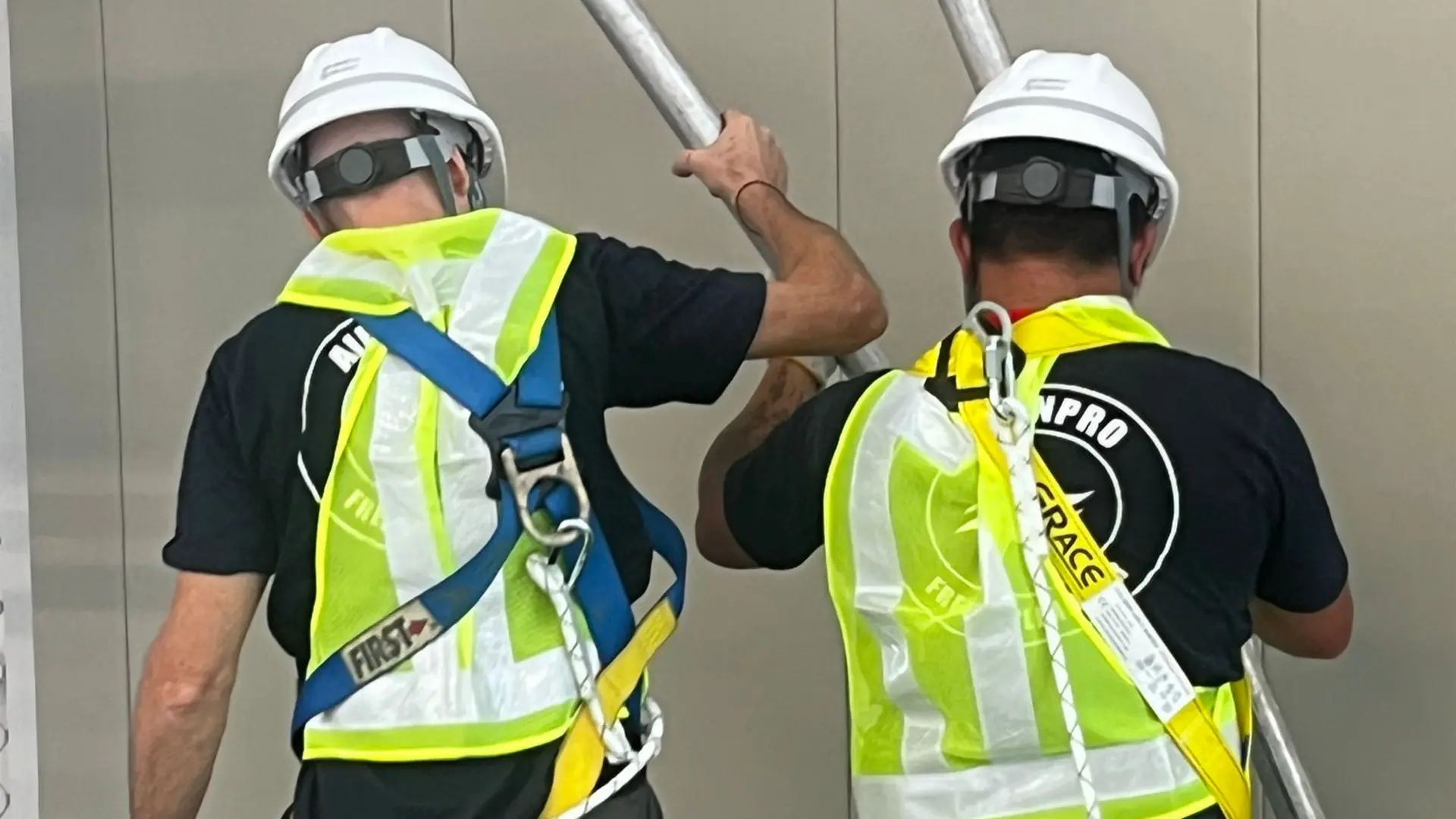 Working at Height: Safe Aircon Servicing in Hong Kong High-Rises 3 AirconPro technicians wearing safety harnesses and hard hats while servicing equipment at height